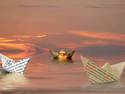 3 paper boats at sunset